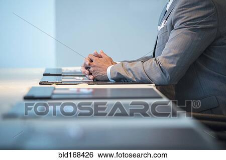 Stock Photograph - Caucasian businessman sitting at conference table. Fotosearch