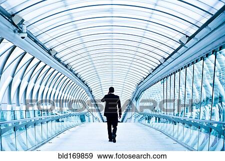 Stock Photo - Caucasian businessman talking on cell phone in tunnel. Fotosearch
