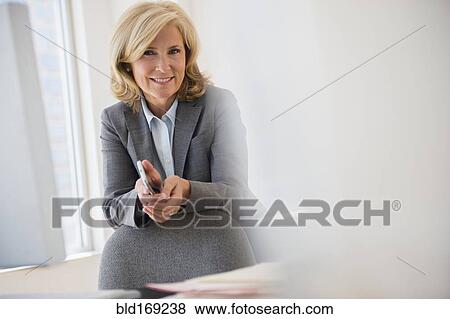 Stock Photo - Caucasian businesswoman smiling in office. Fotosearch