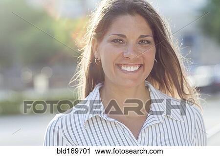 Stock Image - Caucasian businesswoman smiling outdoors. Fotosearch