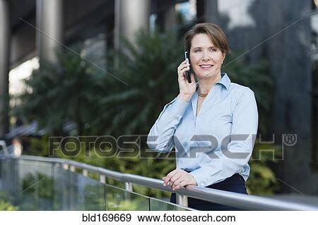 Stock Photo - Caucasian businesswoman talking on cell phone outdoors. Fotosearch