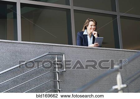 Caucasian businesswoman using digital tablet on balcony View Large Photo Image Stock Image - Caucasian businesswoman using digital tablet on balcony. Fotosearch