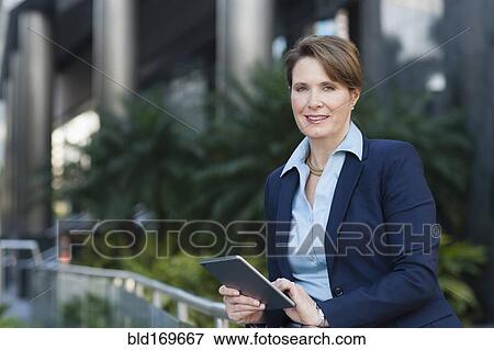 Caucasian businesswoman using digital tablet outdoors View Large Photo Image Stock Photo - Caucasian businesswoman using digital tablet outdoors. Fotosearch