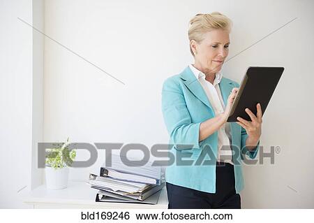 Stock Photograph - Caucasian businesswoman using digital tablet in office. Fotosearch