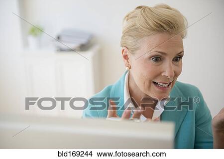 Picture - Caucasian businesswoman working at computer in office. Fotosearch