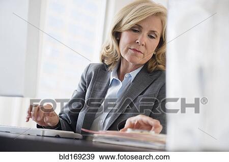 Stock Photo - Caucasian businesswoman working in office. Fotosearch