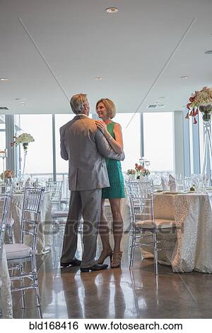 Stock Photograph - Caucasian couple dancing in empty restaurant. Fotosearch