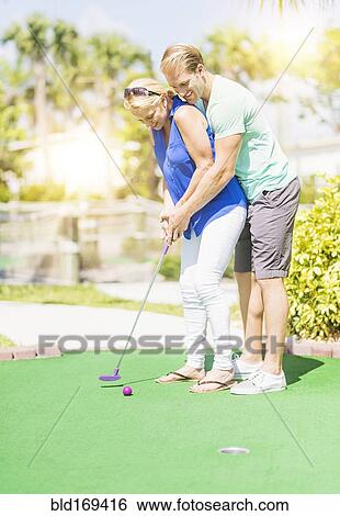 Caucasian couple playing miniature golf View Large Photo Image Stock Photograph - Caucasian couple playing miniature golf. Fotosearch