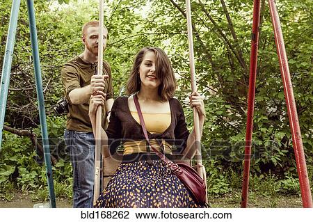 Caucasian couple playing on swing set View Large Photo Image Stock Image - Caucasian couple playing on swing set. Fotosearch