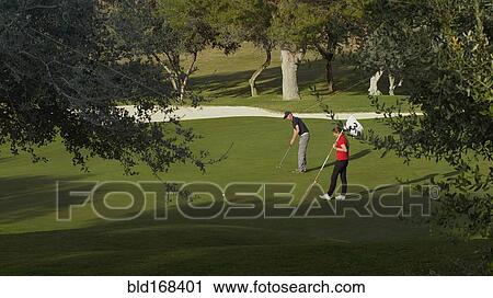 Caucasian couple putting on golf course View Large Photo Image Stock Image - Caucasian couple putting on golf course. Fotosearch