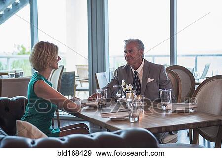 Stock Photo - Caucasian couple sitting in restaurant. Fotosearch