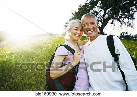 Stock Image - Caucasian couple smiling in tall grass. Fotosearch
