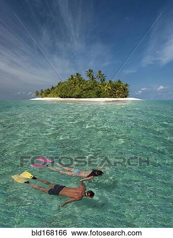 Stock Photograph - Caucasian couple snorkeling off tropical island. Fotosearch