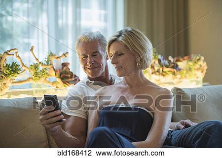 Caucasian couple using cell phone in hotel lobby View Large Photo Image Stock Image - Caucasian couple using cell phone in hotel lobby. Fotosearch