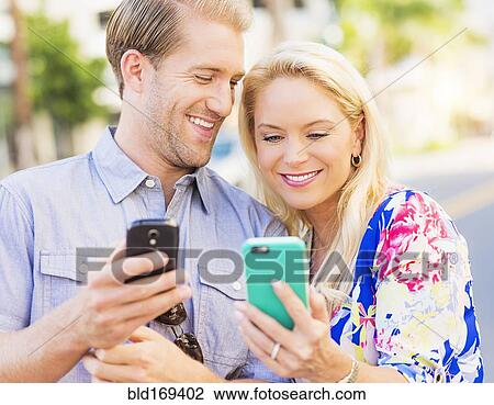Caucasian couple using cell phones View Large Photo Image Stock Image - Caucasian couple using cell phones. Fotosearch
