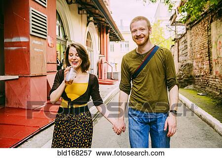 Caucasian couple walking in city street View Large Photo Image Stock Photo - Caucasian couple walking in city street. Fotosearch