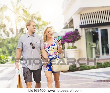 Caucasian couple walking on city sidewalk View Large Photo Image Stock Image - Caucasian couple walking on city sidewalk. Fotosearch