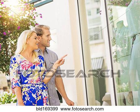 Caucasian couple window shopping outside store View Large Photo Image Stock Photo - Caucasian couple window shopping outside store. Fotosearch