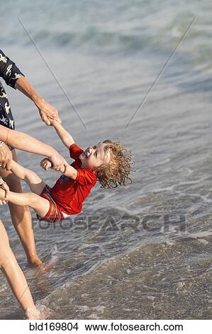 Picture - Caucasian family playing on beach. Fotosearch