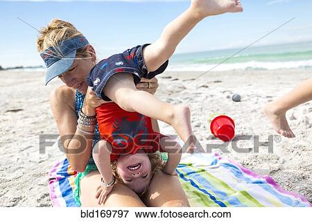 Stock Photo - Caucasian family playing on beach. Fotosearch