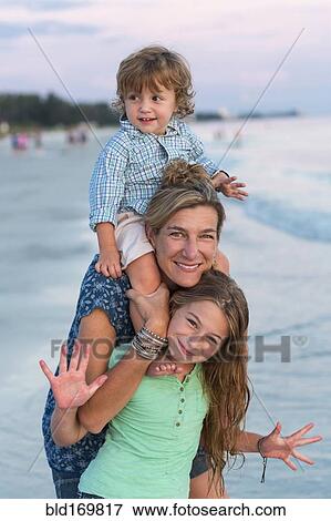Stock Photo - Caucasian family playing on beach. Fotosearch