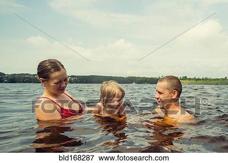 Stock Photo - Caucasian family swimming in lake. Fotosearch
