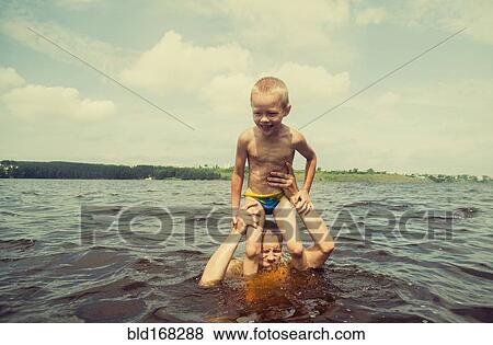 Caucasian father and son swimming in lake View Large Photo Image Stock Photo - Caucasian father and son swimming in lake. Fotosearch
