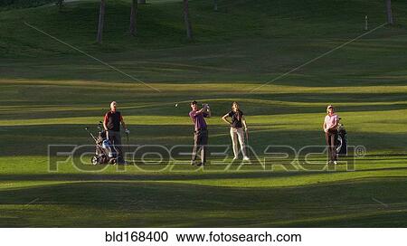 Caucasian friends playing golf on course View Large Photo Image Stock Image - Caucasian friends playing golf on course. Fotosearch