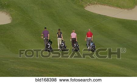 Caucasian friends pulling golf bags on course View Large Photo Image Stock Photo - Caucasian friends pulling golf bags on course. Fotosearch