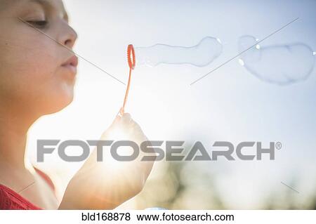Caucasian girl blowing bubbles outdoors View Large Photo Image Stock Photo - Caucasian girl blowing bubbles outdoors. Fotosearch