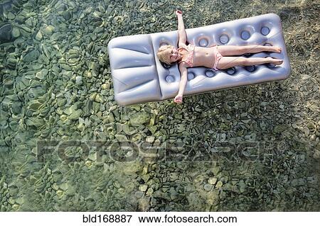 Caucasian girl floating on raft in lake View Large Photo Image Stock Photo - Caucasian girl floating on raft in lake. Fotosearch