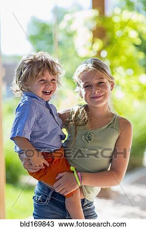 Caucasian girl holding baby brother View Large Photo Image Stock Image - Caucasian girl holding baby brother. Fotosearch