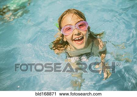 Stock Image - Caucasian girl playing in swimming pool. Fotosearch