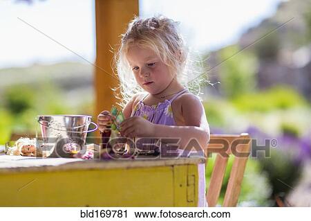 Caucasian girl playing with dolls at table View Large Photo Image Stock Image - Caucasian girl playing with dolls at table. Fotosearch