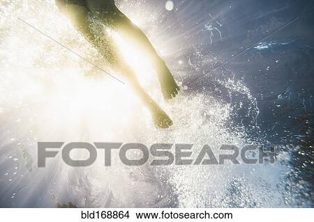 Picture - Caucasian girl swimming underwater in swimming pool. Fotosearch
