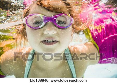Caucasian girl swimming underwater in swimming pool View Large Photo Image Stock Photograph - Caucasian girl swimming underwater in swimming pool. Fotosearch