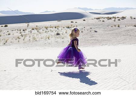 Picture - Caucasian girl walking on desert sand dunes. Fotosearch