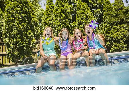 Stock Image - Caucasian girls cheering at swimming pool. Fotosearch