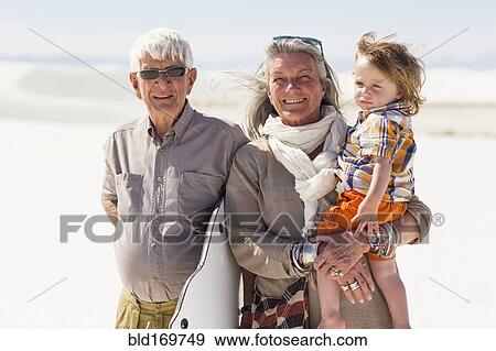 Stock Photo - Caucasian grandparents and grandson smiling in desert. Fotosearch