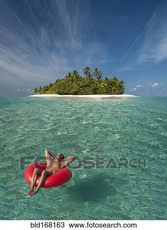 Caucasian man floating near tropical island View Large Photo Image Stock Image - Caucasian man floating near tropical island. Fotosearch