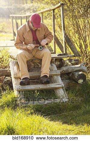 Caucasian man loading fishing pole on steps View Large Photo Image Stock Image - Caucasian man loading fishing pole on steps. Fotosearch