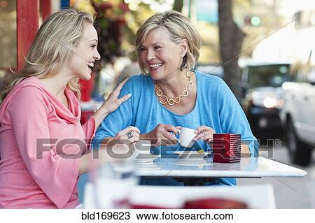 Caucasian mother and daughter drinking coffee at sidewalk cafe View Large Photo Image Stock Image - Caucasian mother and daughter drinking coffee at sidewalk cafe. Fotosearch