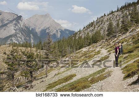 Stock Image - Caucasian mother and son hiking on remote hillside. Fotosearch