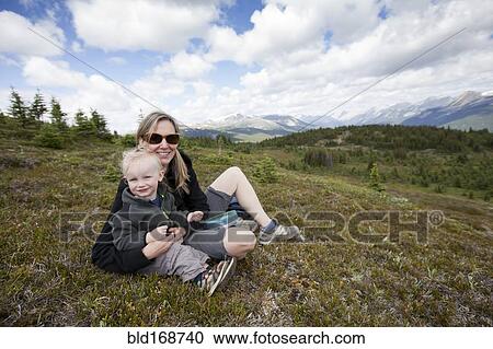 Caucasian mother and son sitting on remote hilltop View Large Photo Image Stock Image - Caucasian mother and son sitting on remote hilltop. Fotosearch