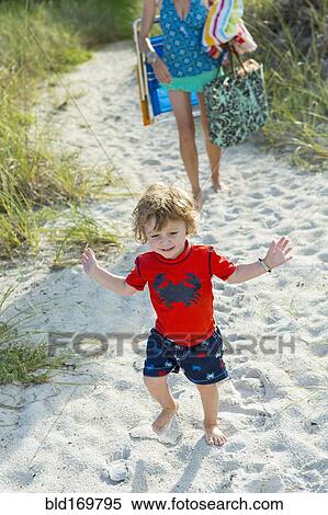 Stock Photography - Caucasian mother and son walking on beach. Fotosearch