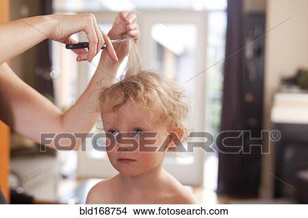 Picture - Caucasian mother cutting hair of son. Fotosearch