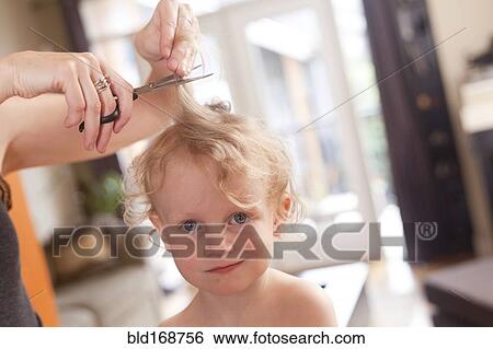 Stock Photograph - Caucasian mother cutting hair of son. Fotosearch
