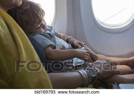 Caucasian mother holding baby son on airplane View Large Photo Image Stock Image - Caucasian mother holding baby son on airplane. Fotosearch