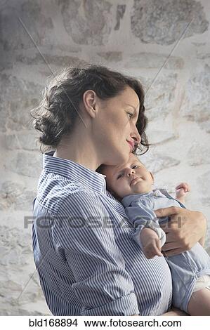 Picture - Caucasian mother holding son. Fotosearch