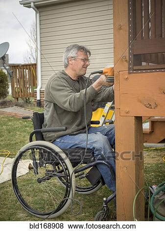 Caucasian paraplegic man wood working in backyard View Large Photo Image Stock Photo - Caucasian paraplegic man wood working in backyard. Fotosearch